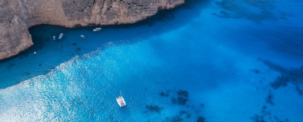 Free Image of Aerial View of Beach With Boats in the Water 