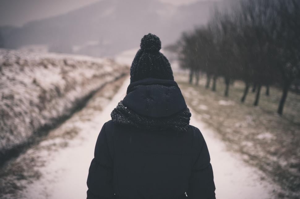 Free Image of Person Walking Down a Snow Covered Road 