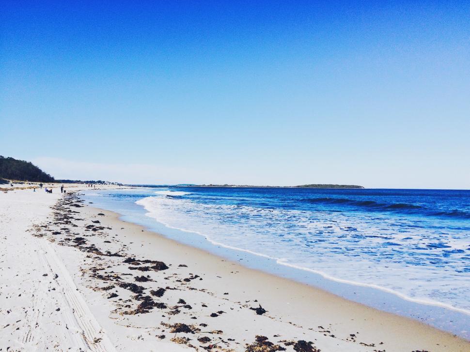 Free Image of Sandy Beach With Waves Cresting Shore 