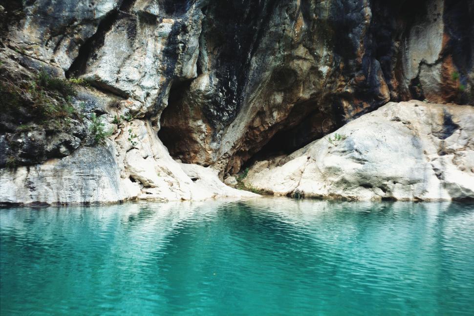 Free Image of Rocky Cliff Surrounding Body of Water 