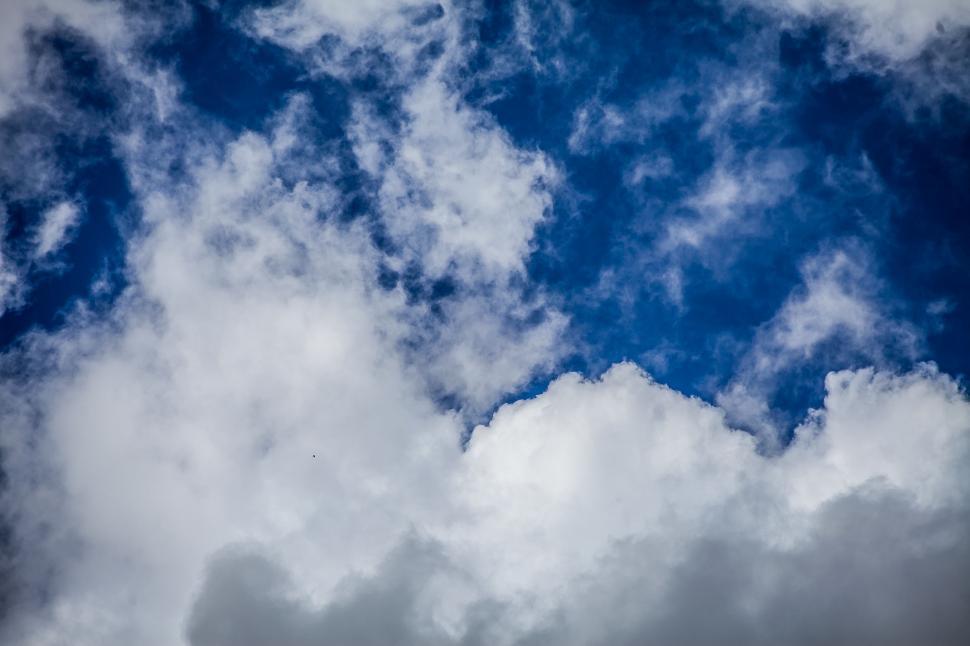 Free Image of Plane Flying Through Cloudy Blue Sky 