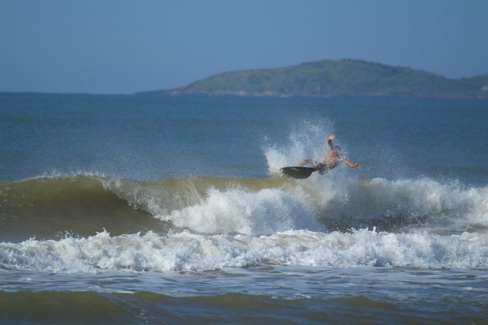 Free Image of Man Riding Wave on Surfboard 