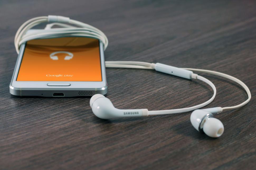 Free Image of Cell Phone Connected to Ear Buds 