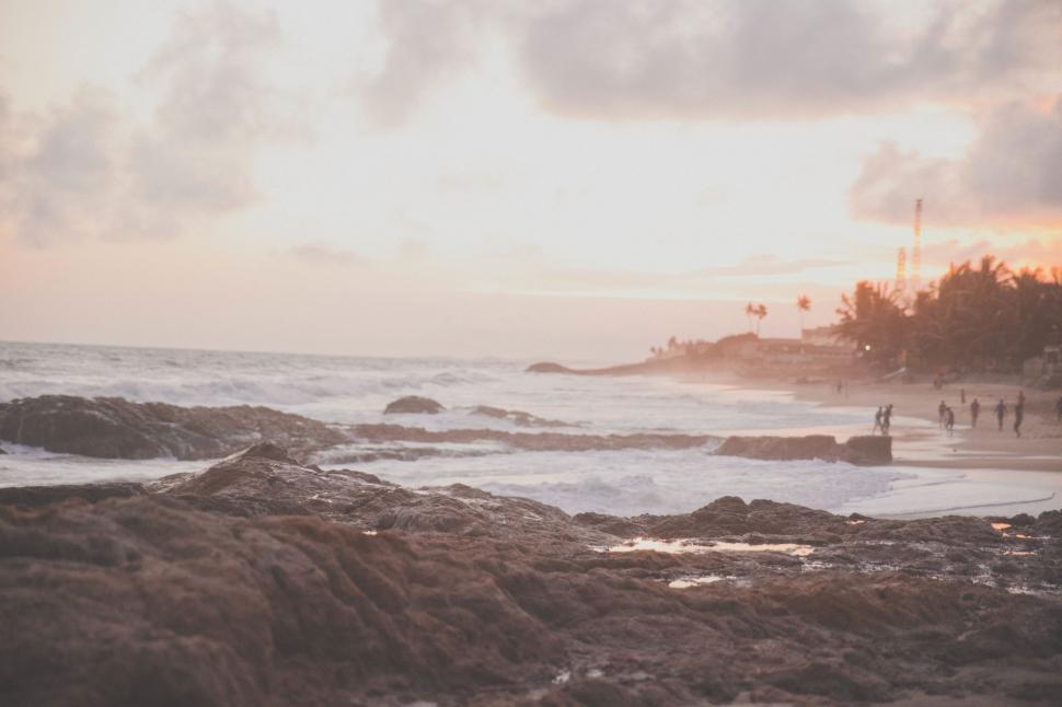 Free Image of Group of People Standing on Top of Beach Next to Ocean 