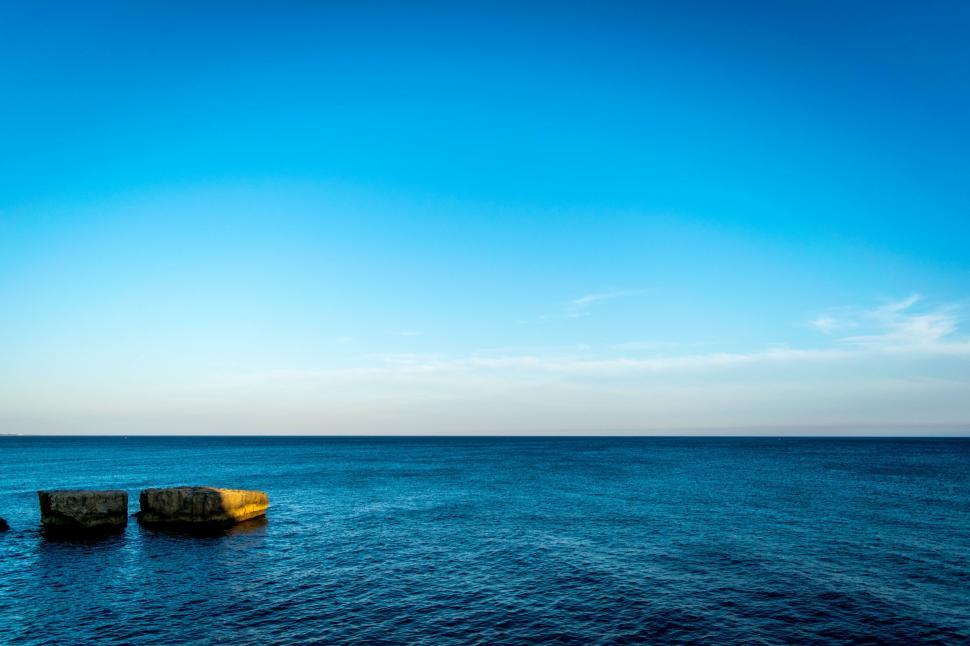 Free Image of Rocky Outcrops in Vast Water Body 