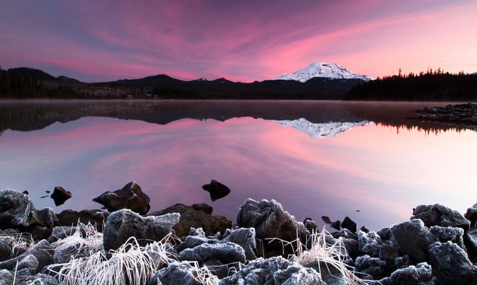 Free Image of Lake Surrounded by Rocks With Mountain in Background 