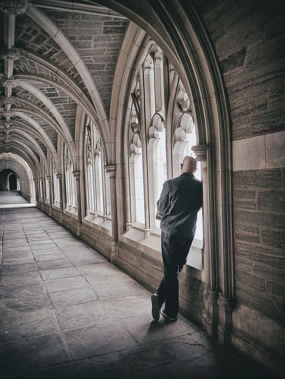 Free Image of Man Leaning Against Window in Building 