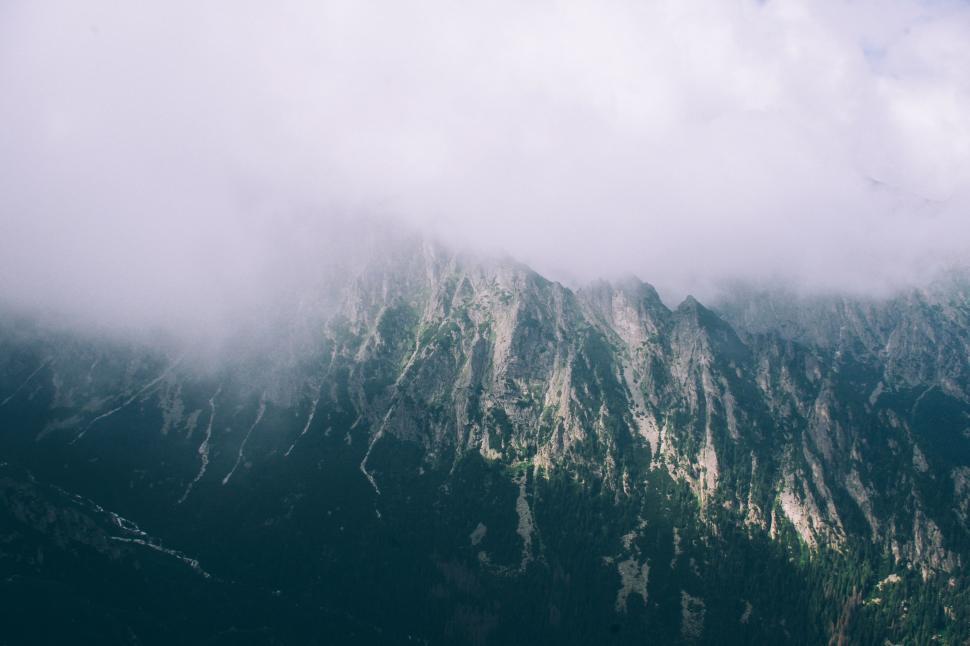 Free Image of Plane Soaring Above Cloud-Covered Mountain 