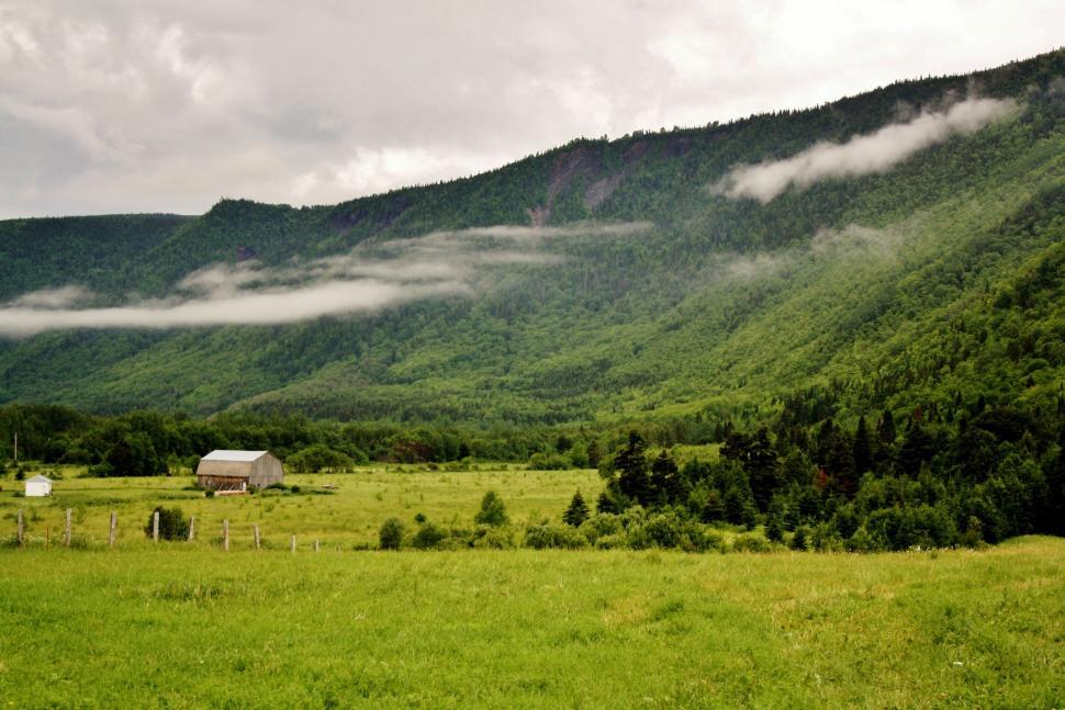 Free Image of Grassy Field With Barn and Mountains 