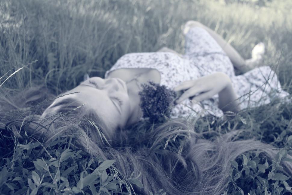 Free Image of Woman Laying in Grass With Eyes Closed 