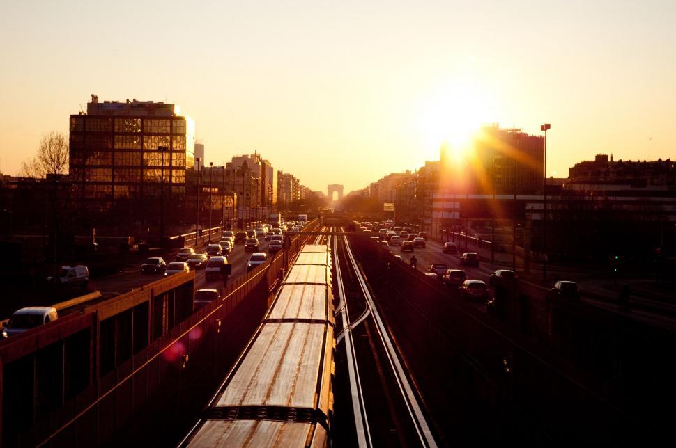 Free Image of Train Traveling Down Train Track Next to Tall Buildings 