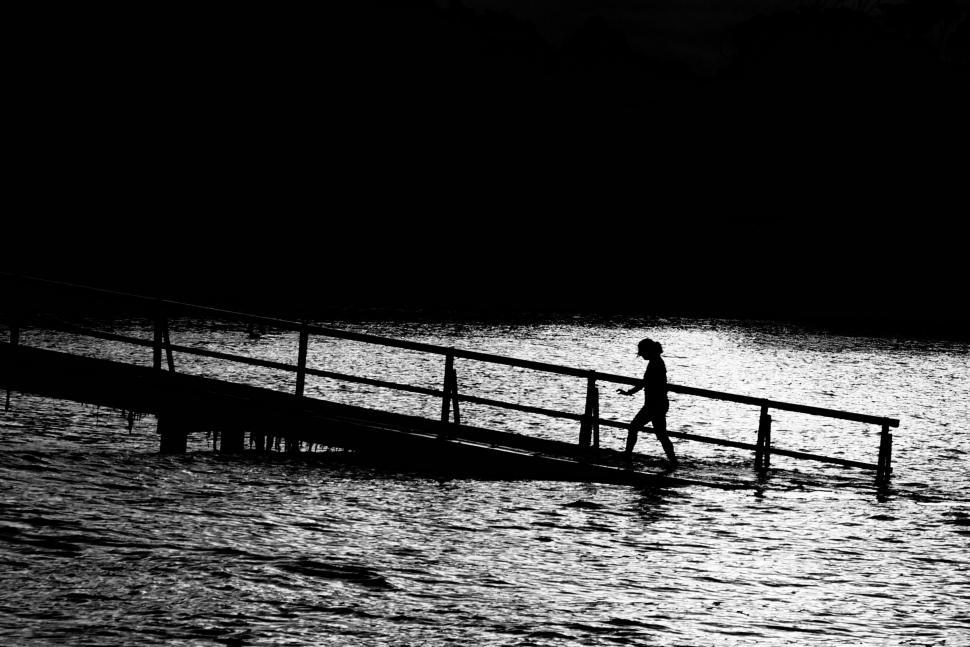 Free Image of Person Crossing Bridge Over Waterway 