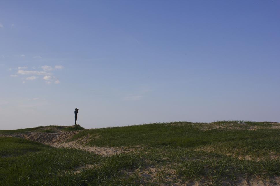Free Image of Person Standing on Top of Grass Covered Hill 