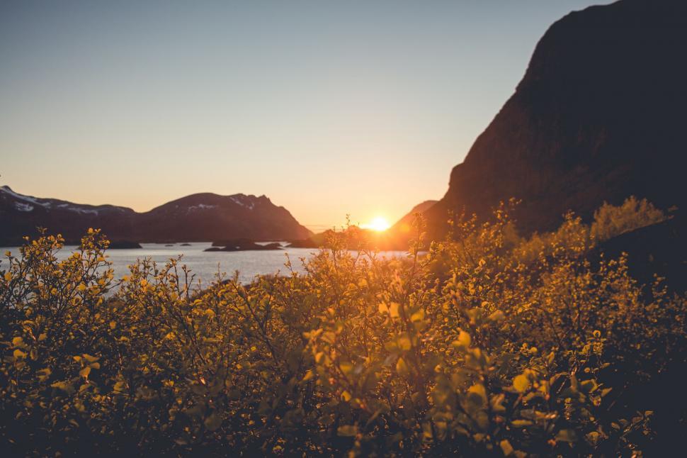Free Image of The Sun Sets Over Mountains and Water 