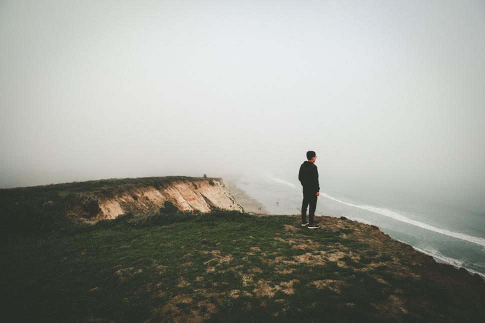 Free Image of Man Standing on Top of Hill Next to Helicopter 