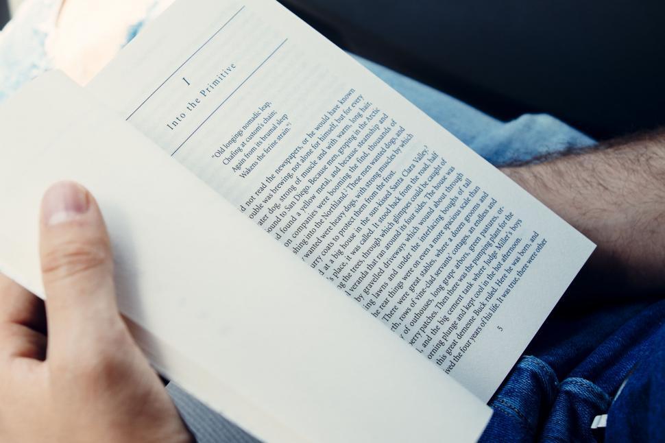Free Image of Person Reading a Book While Sitting Down 
