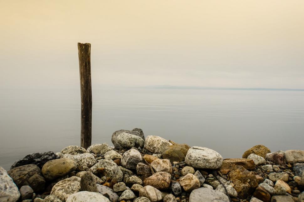 Free Image of Wooden Pole Resting on Pile of Rocks 