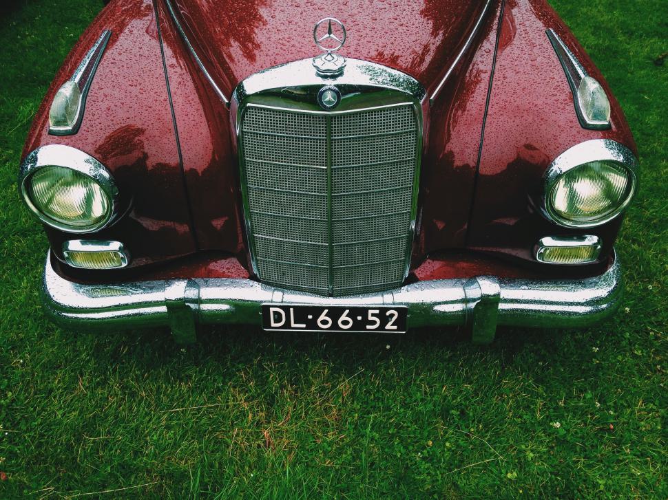Free Image of Red Car Parked on Lush Green Field 