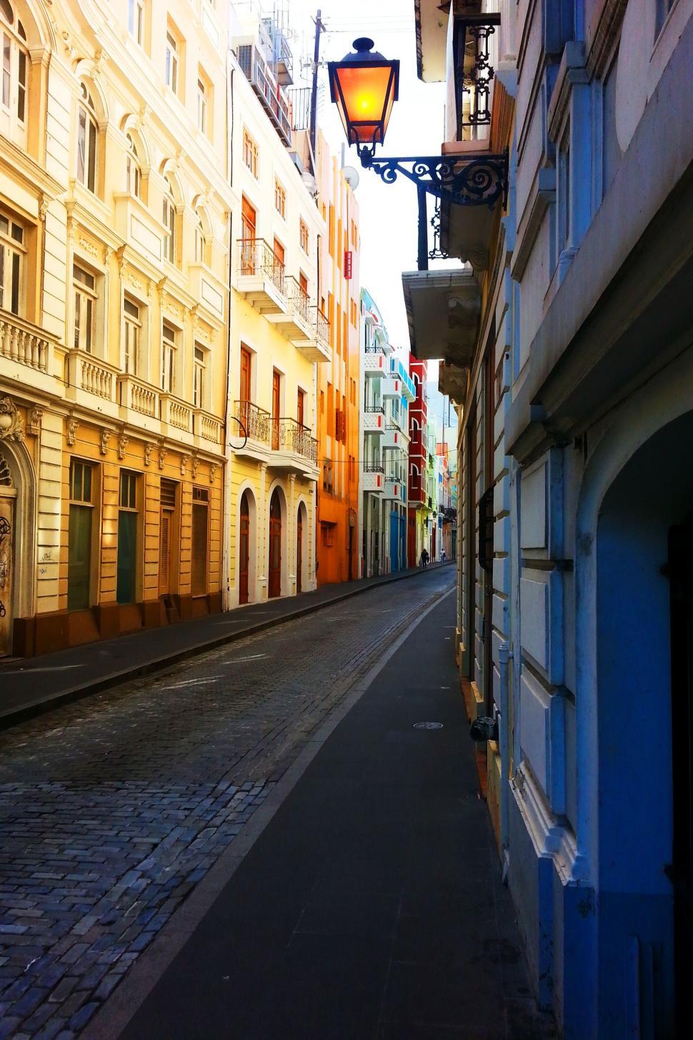 Free Image of Urban Scene: Narrow Street With Tall Buildings and Street Light 