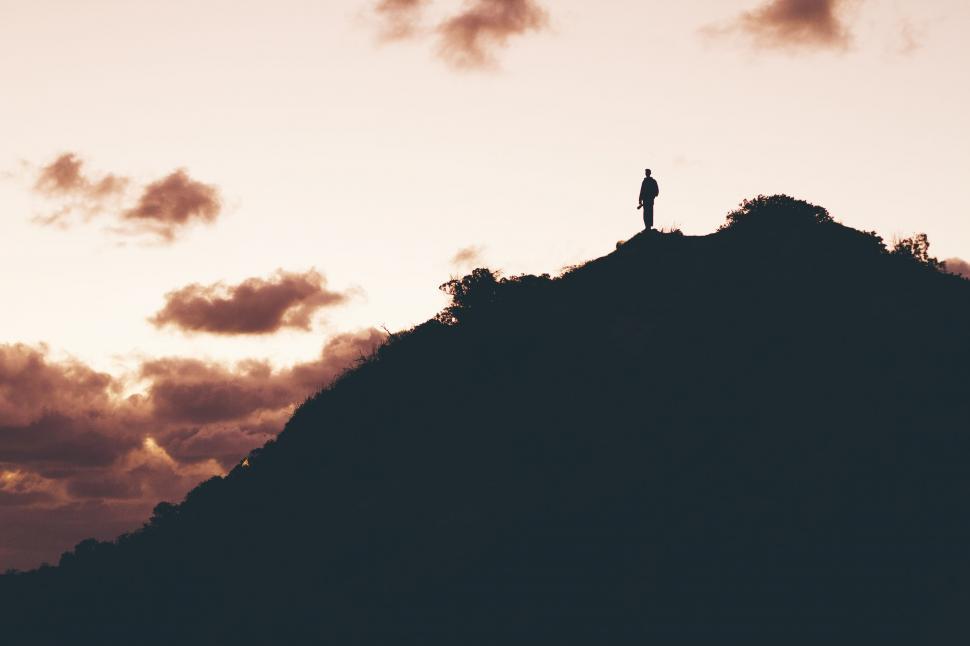 Free Image of Person Standing on Top of Mountain at Sunset 