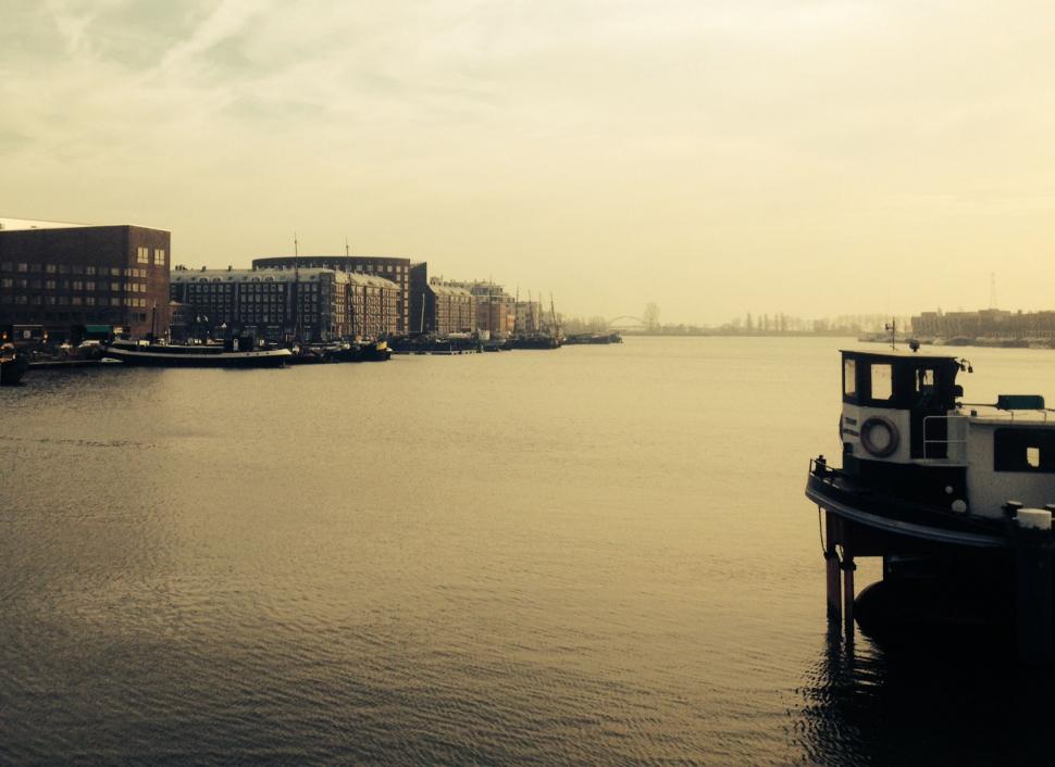 Free Image of Boat Floating on River Next to Tall Buildings 