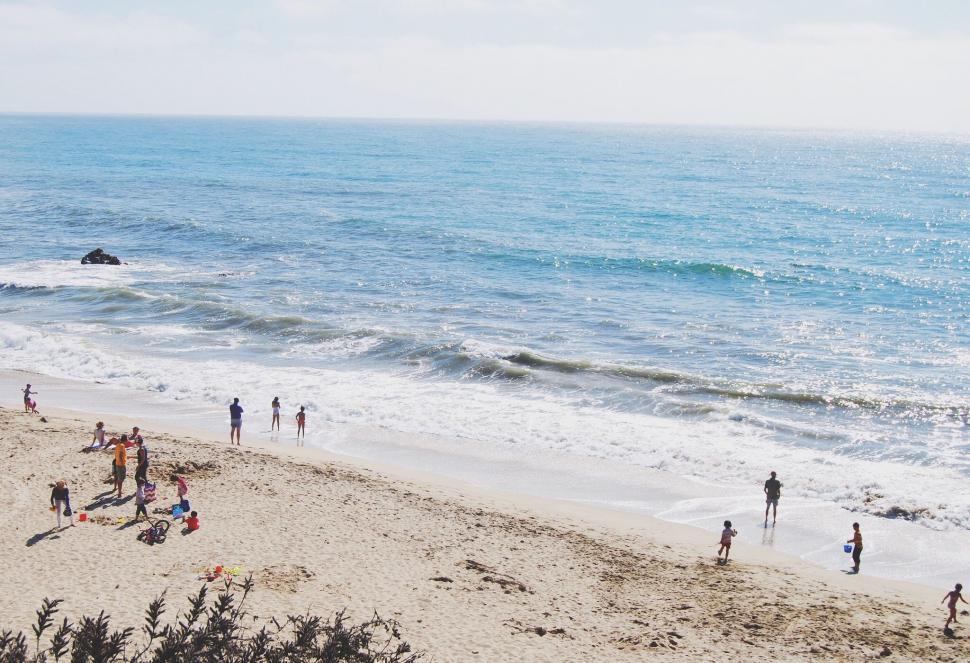 Free Image of Group of People Standing on Top of a Sandy Beach 