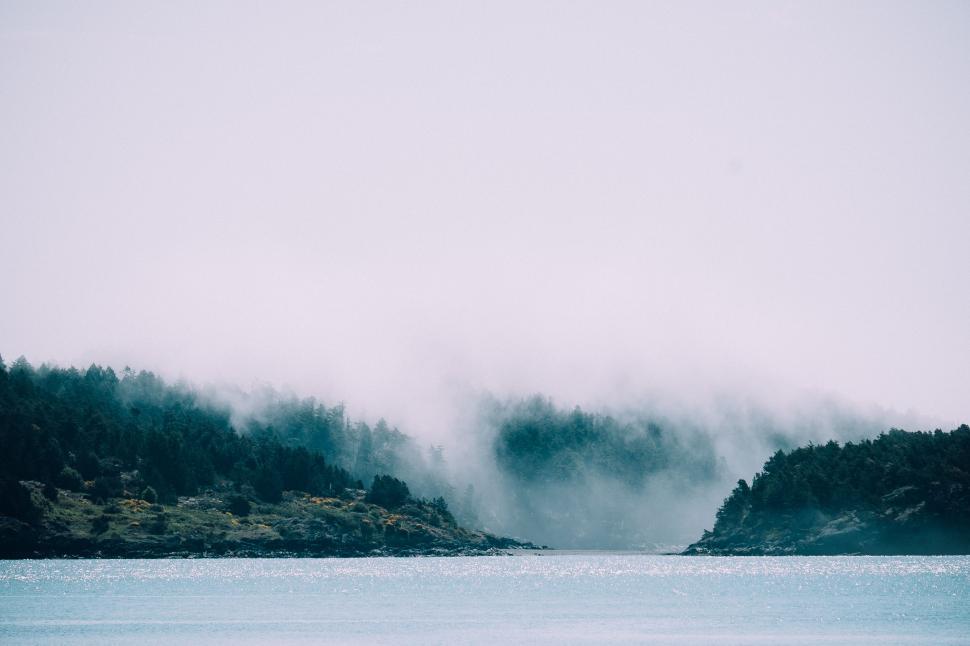 Free Image of Two Cars Driving on Foggy Day Over Body of Water 