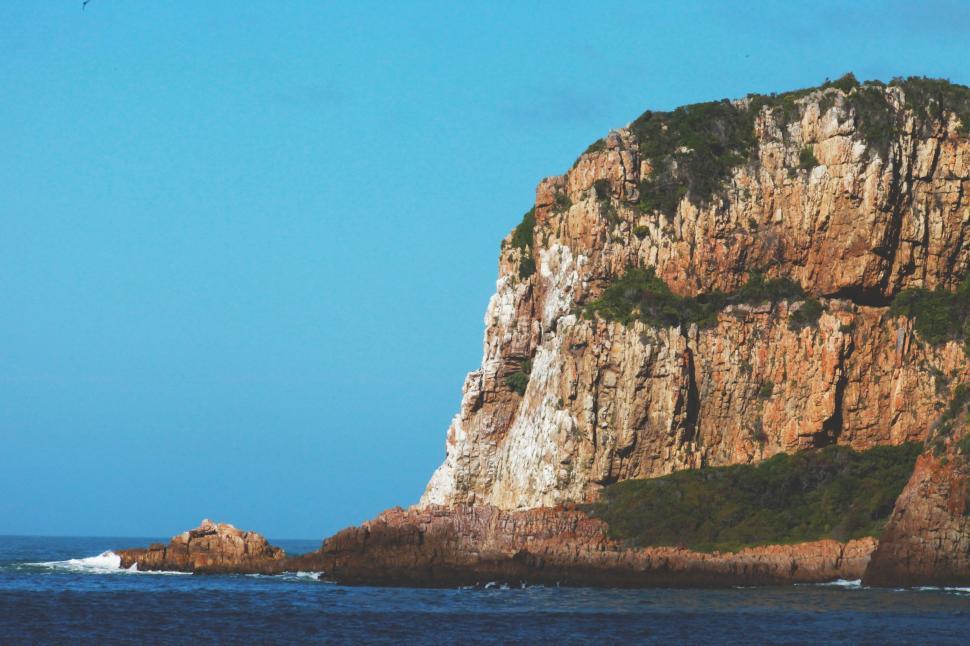 Free Image of Large Rock Emerges From Ocean Waters 