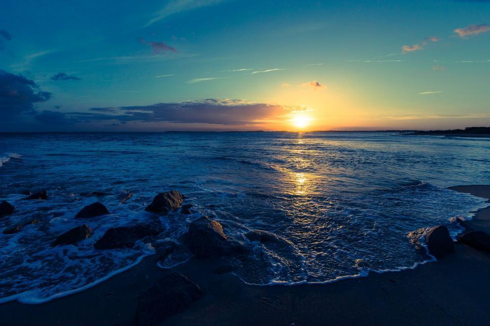 Free Image of Sun Setting Over Ocean on Beach 