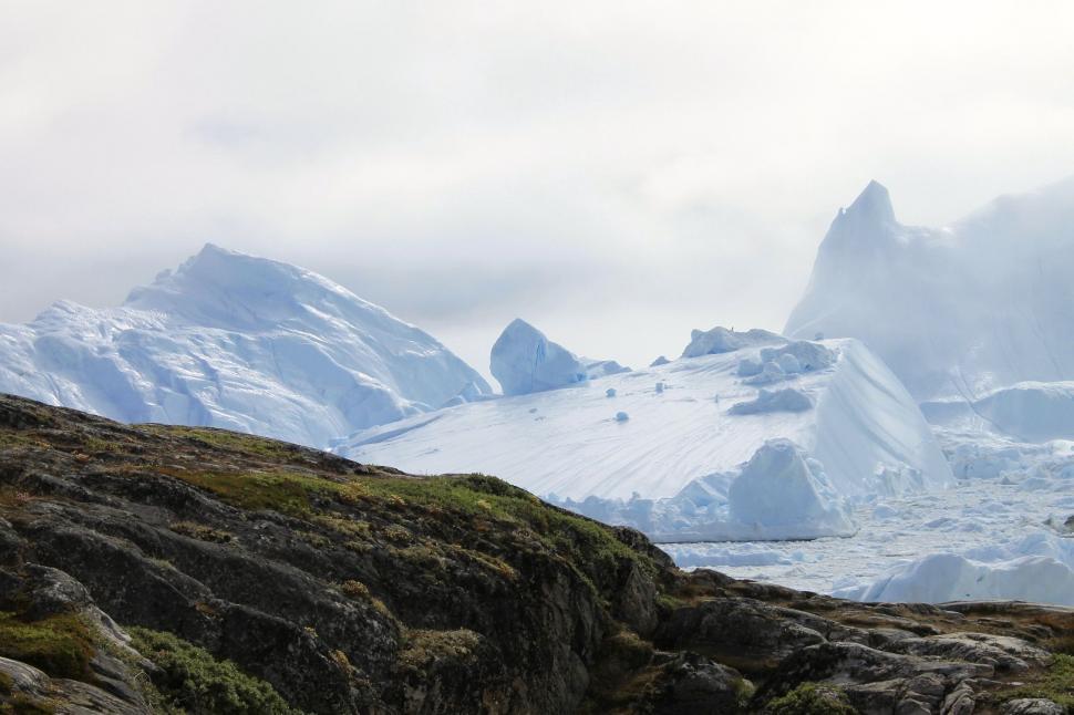Free Image of Man Standing on Snow Covered Mountain Summit 