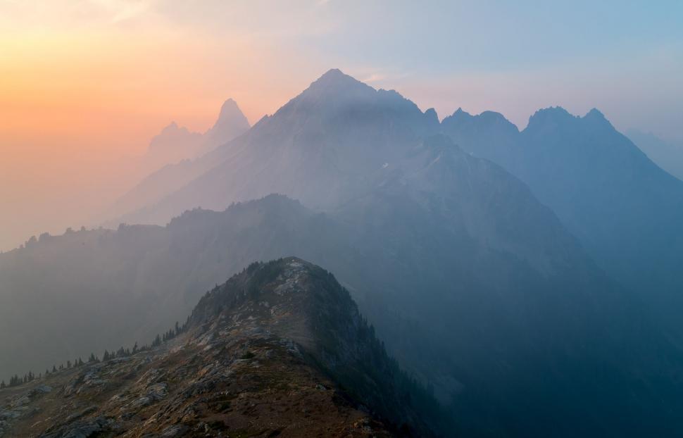 Free Image of Majestic Mountain Range Silhouetted Against Sunset Sky 