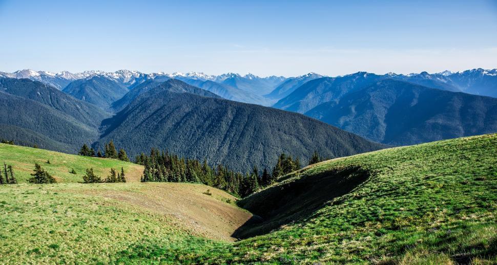 Free Image of A Panoramic View of Mountains From Grassy Hilltop 