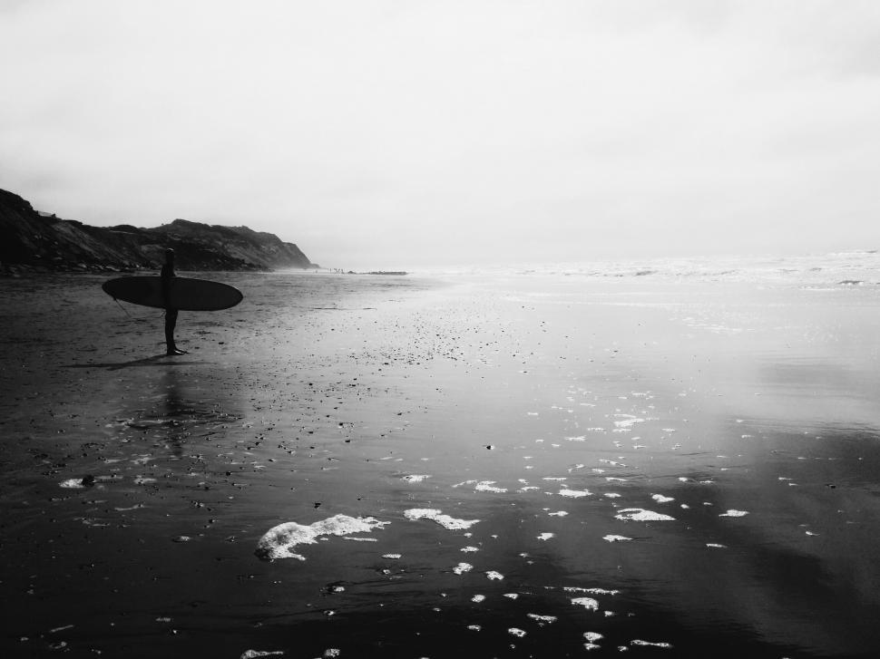 Free Image of Person Holding Surfboard on Wet Beach 