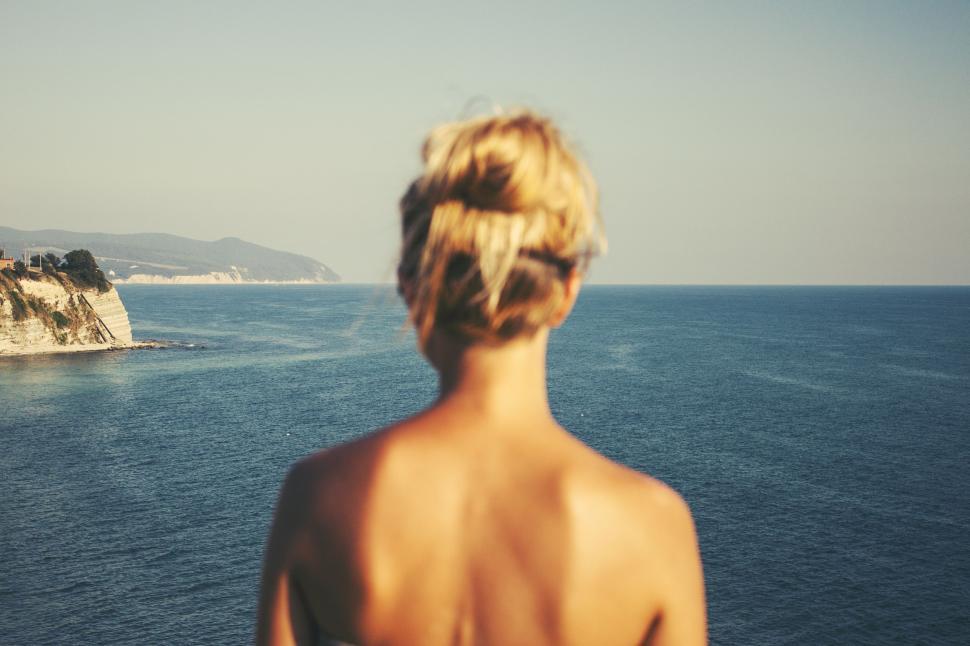 Free Image of Woman Standing on Boat Looking Out at Ocean 