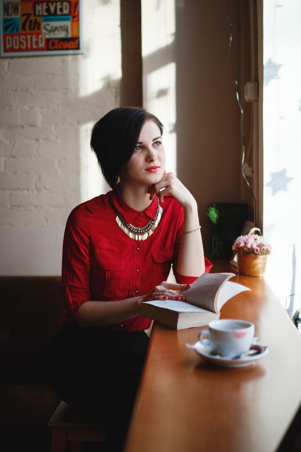 Free Image of Woman Sitting at Table in Front of Window 