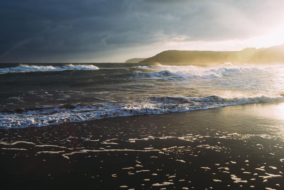 Free Image of Sun Shines Through Clouds Over Ocean 