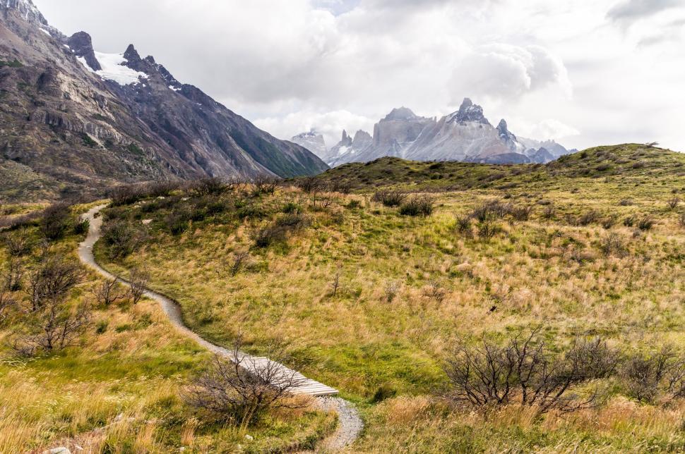 Free Image of Scenic Trail in Grassy Field With Mountains 