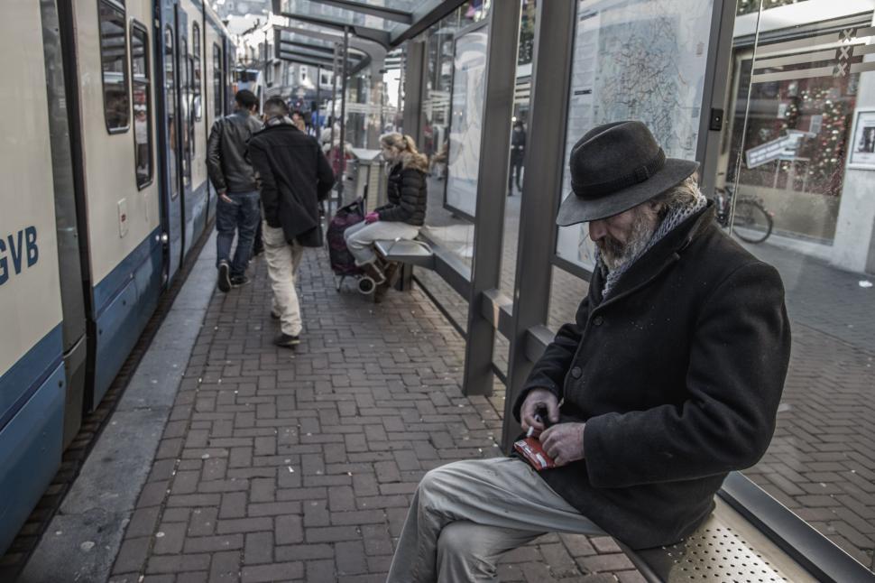 Free Image of Man Sitting on Bench Next to Train 