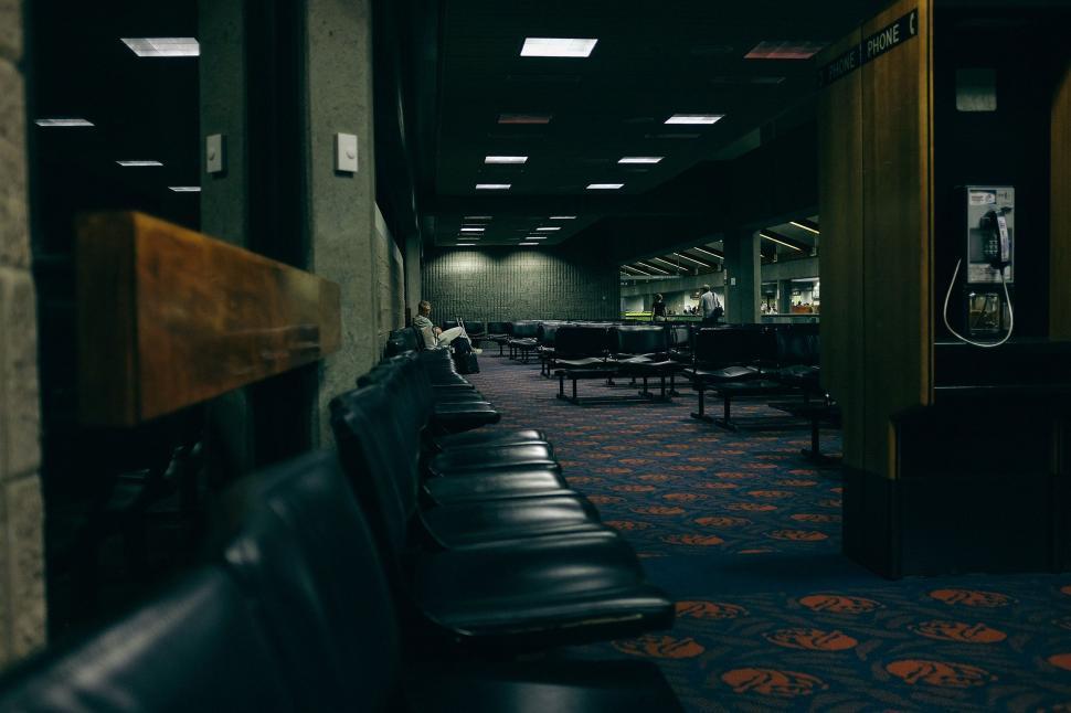 Free Image of Long Row of Benches in a Dark Room 