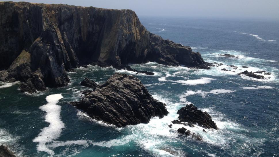 Free Image of Rocky Shoreline Next to Large Body of Water 