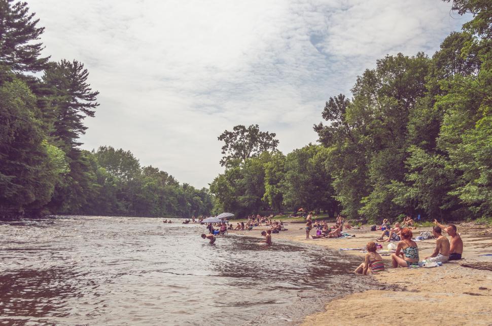 Free Image of Group of People Sitting on Beach Next to Body of Water 
