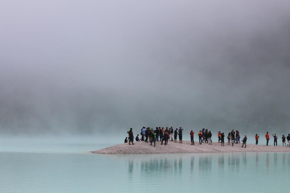 Free Image of Group of People Standing on Beach by Water 