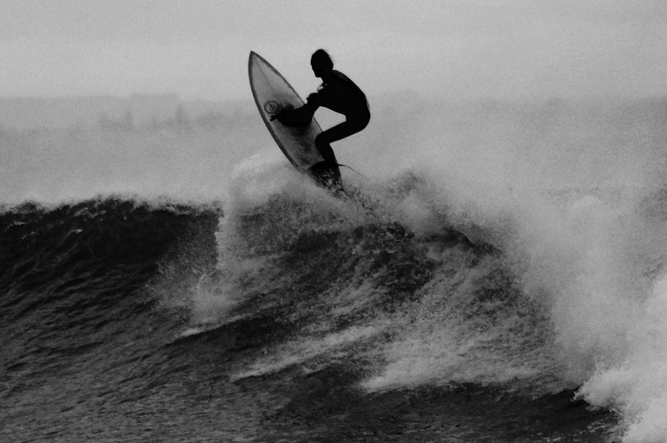 Free Image of Man Riding Wave on Surfboard 