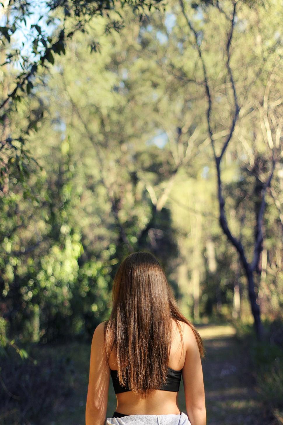 Free Image of Woman Walking Down a Path in the Woods 