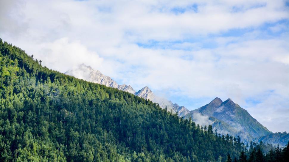 Free Image of Majestic Mountain Range With Trees and Clouds 