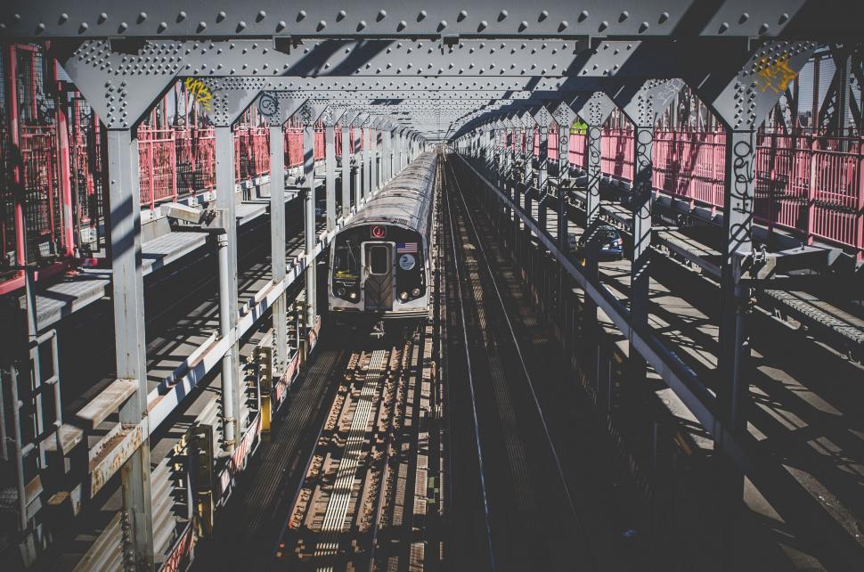 Free Image of Train Traveling Through Train Station Next to Tall Buildings 