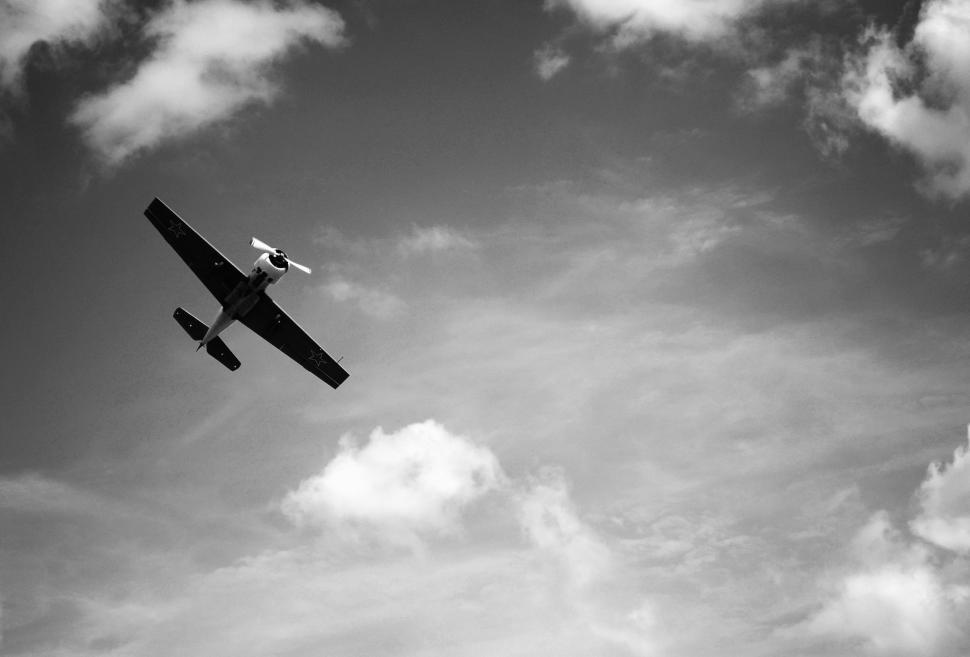Free Image of Small Airplane Flying Through Cloudy Sky 