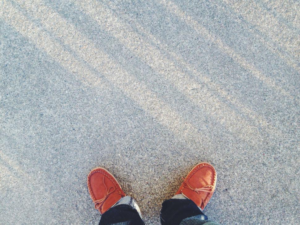 Free Image of Person Standing in Sand With Feet Up 