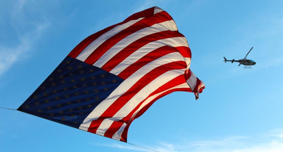 Free Image of Helicopter Flying Next to Large American Flag 