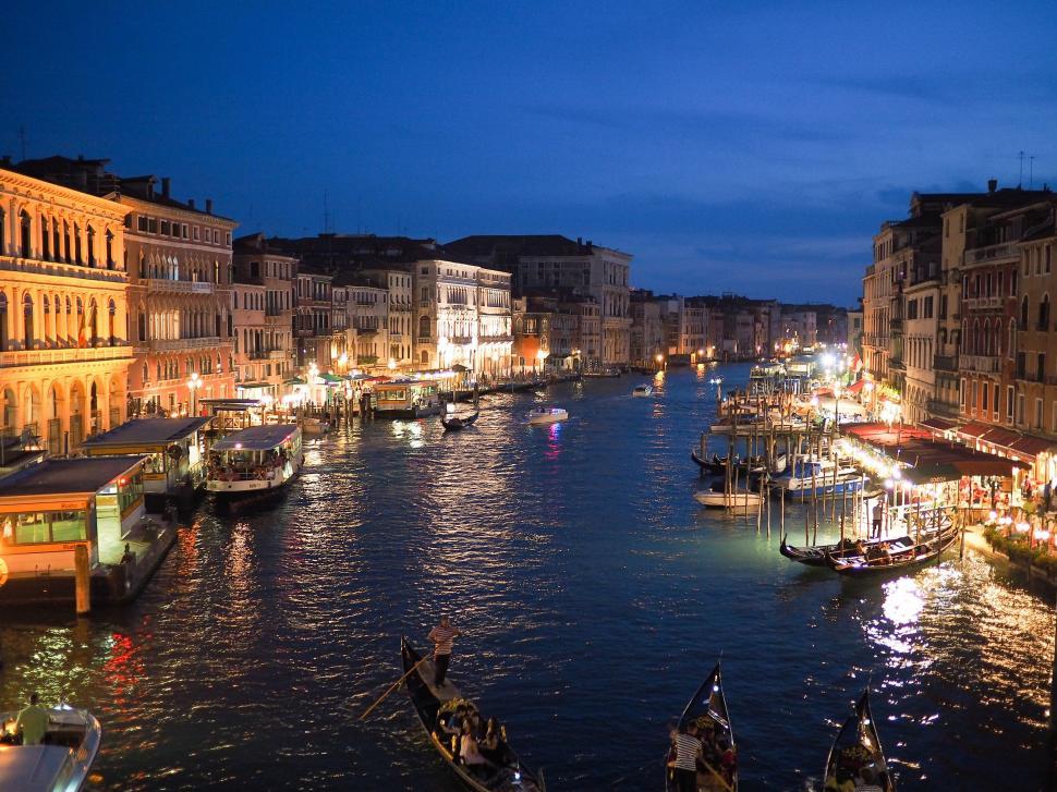 Free Image of River Filled With Boats Next to Tall Buildings 